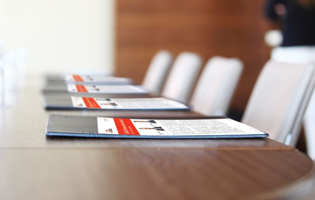photo of a table and empty chairs with MEA Forensic articles in front of them